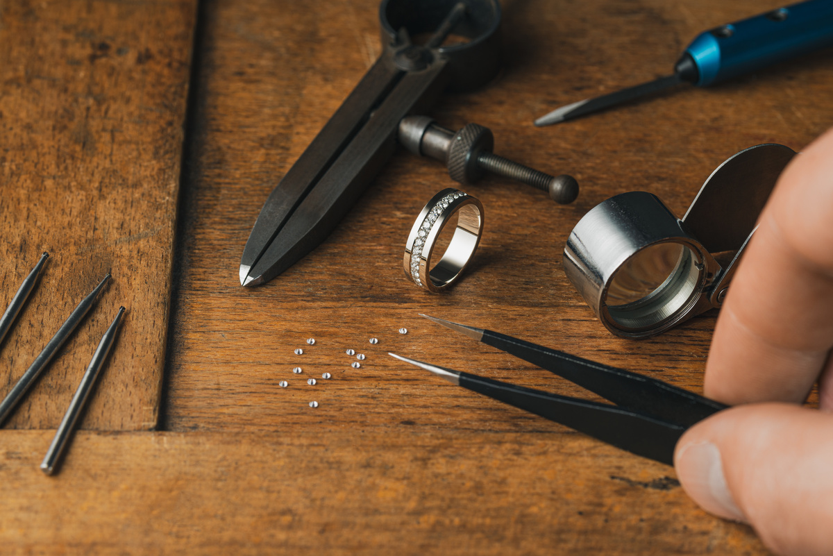 Outils de bijoutier joaillier avec une bague en cours d'insertion de petits diamants.