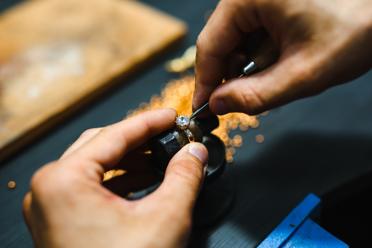 Travail de précision sur une bague en diamant dans un atelier de fabrication de bijoux.